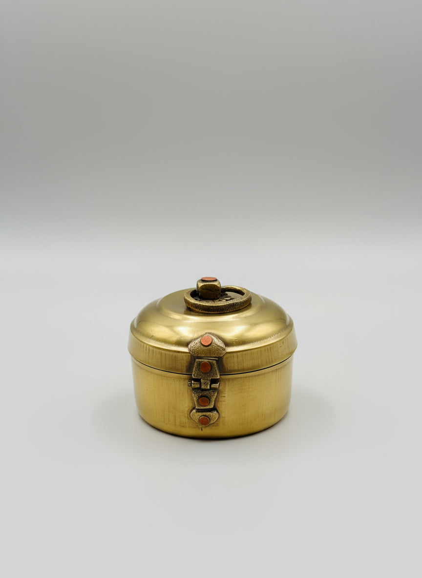 Brass container with lid on a texturEd surface