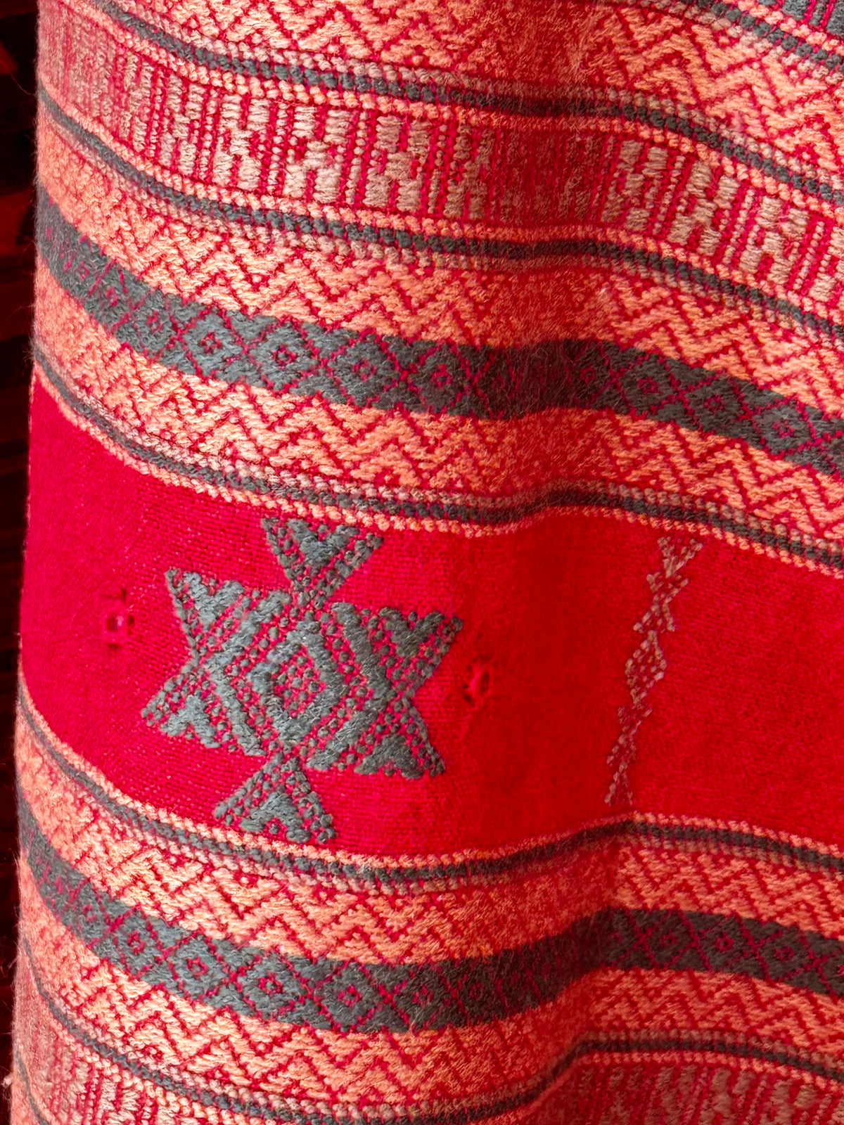 Close-up of a red Soof embroidered stole with hand embroidered geometric patterns
