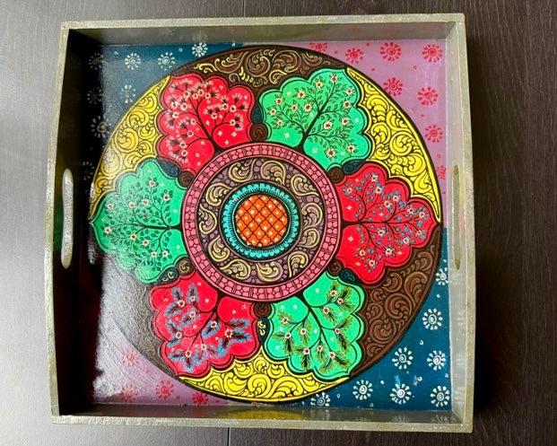 Decorative tray with a colorful circular design on a wooden surface