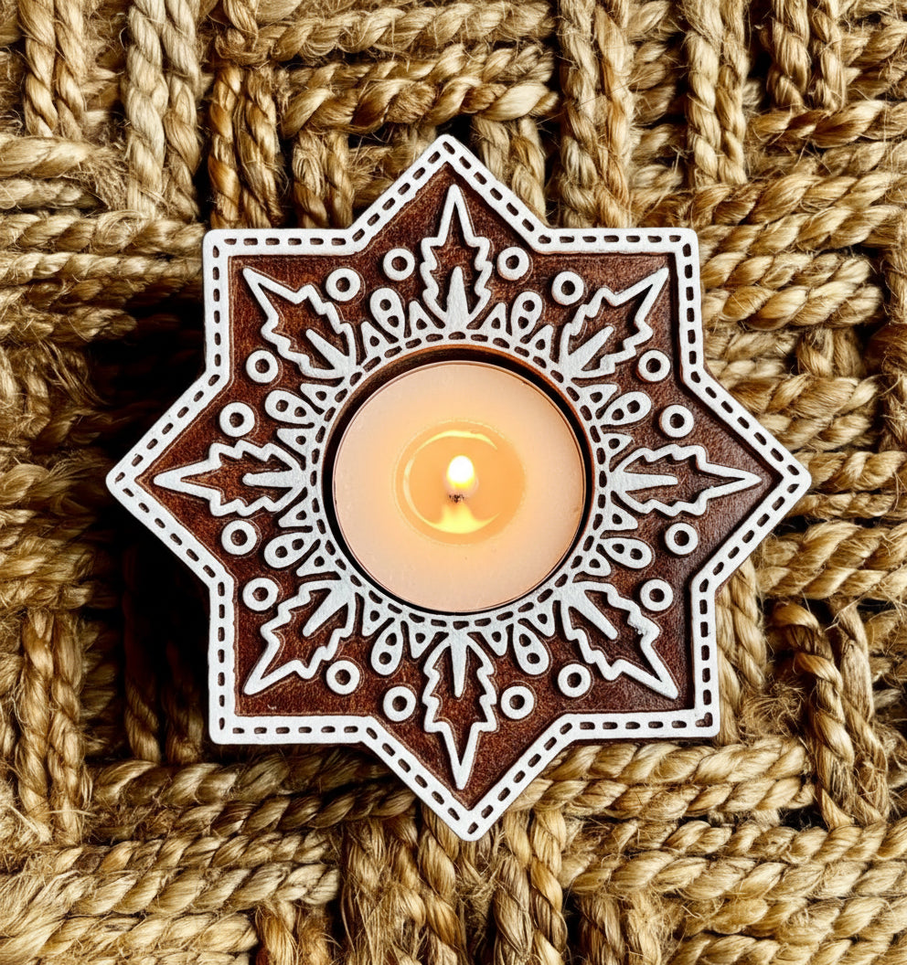 Decorative star-shaped candle holder with intricate patterns on a woven background
