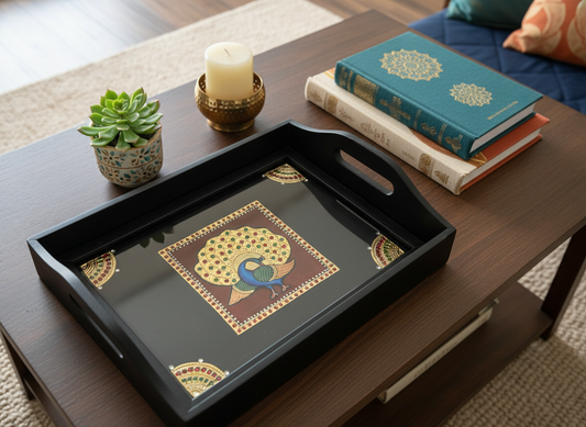 Decorative tray with a geometric design on a wooden table with books and a candle.