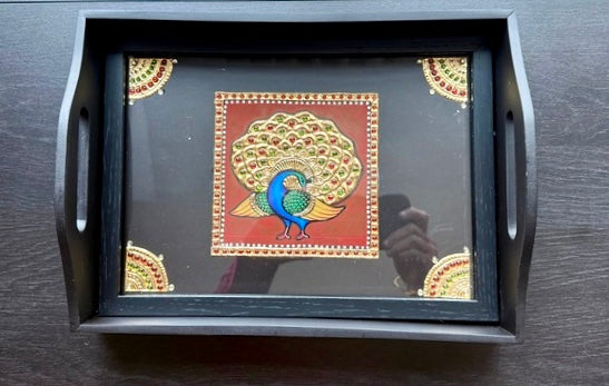 Decorative tray with a peacock design on a wooden surface