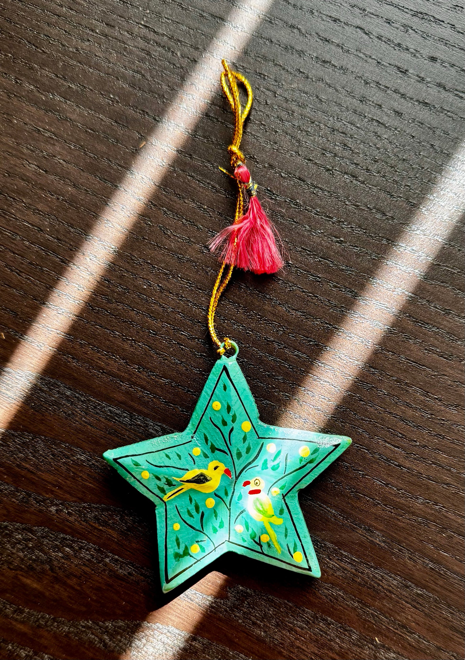 Decorative star-shaped ornament with birds on a wooden surface