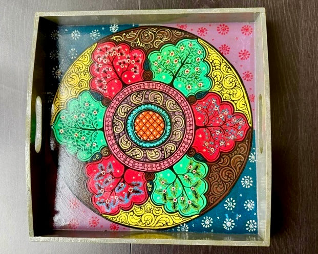Decorative Pattachitra art tray with a colorful floral design on a wooden surface