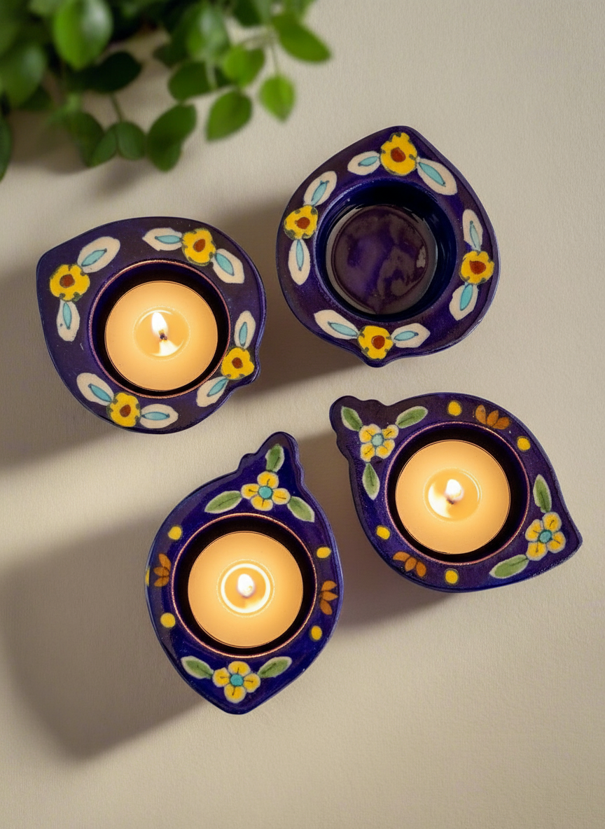 Three indigo decorative candle holders with candles on a light background